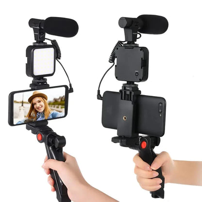 Handheld video camera rig with smartphone holder, microphone, and light on a white background